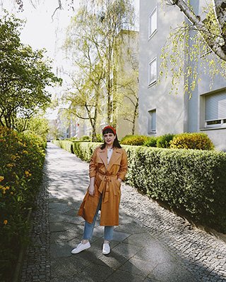 Frau mit gestreiftem Rock und Jeansjacke