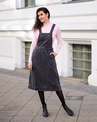 Frau trägt Jeanskleid und rosa Longsleeve