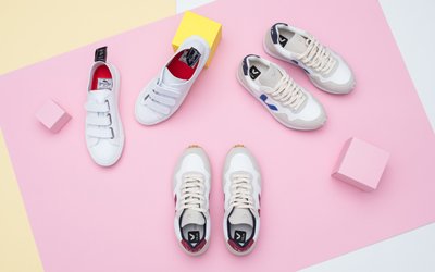 Weiße Sneaker liegen auf farbigen Hintergrund