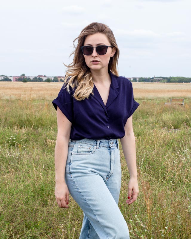 Frau trägt blaue Bluse und Jeans