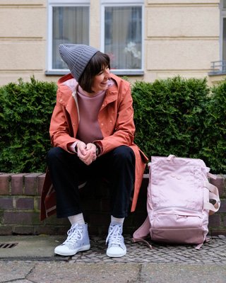 Frau trägt Regenjacke und Rucksack